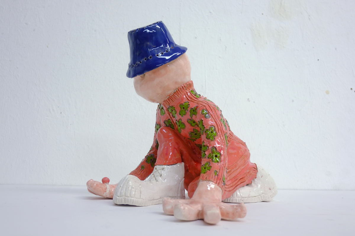 ceramic sculpture of person fitting new sneakers